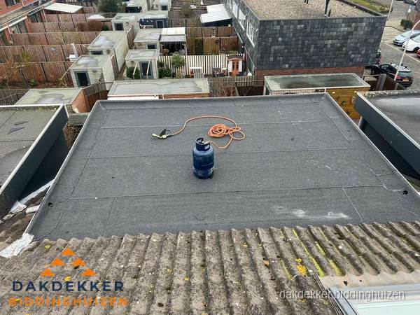 Plat dak met bitumen dakbedekking en brander in Biddinghuizen