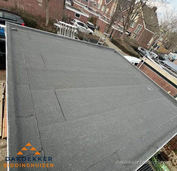 Nieuwe bitumen dakbedekking op plat dak van garage in Biddinghuizen