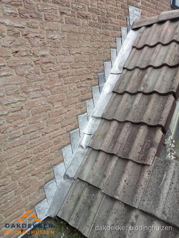Loodslabben langs dakaansluiting bij bakstenen muur in Biddinghuizen