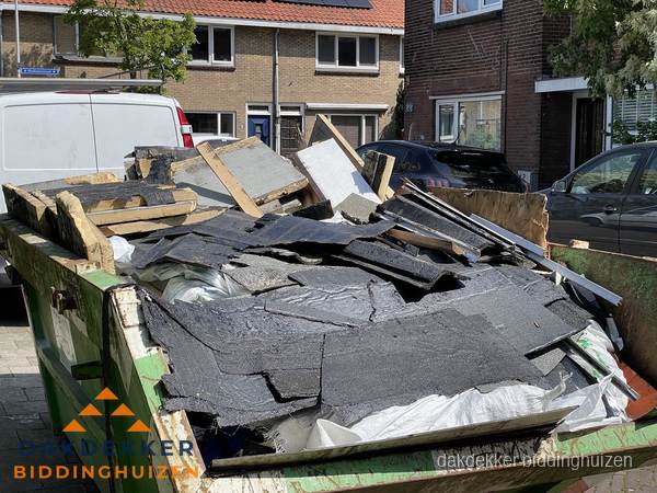 Afvalcontainer met gesloopt dakmateriaal tijdens dakkapel renovatie in Biddinghuizen