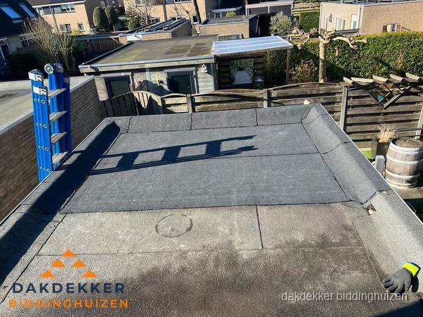 Dakdekker bij bitumen plat dak renovatie in Biddinghuizen