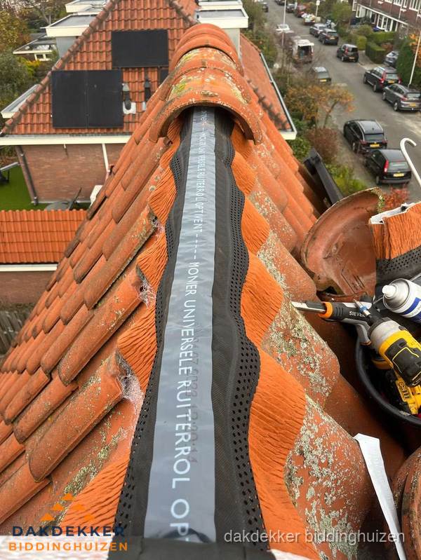 Dakdekker vervangt nokvorst met ruiterrol op pannendak in Biddinghuizen