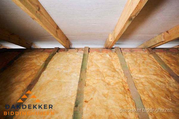 Dakisolatie met glaswol tussen dakspanten in Biddinghuizen
