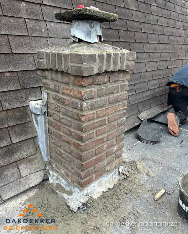 Schoorsteen reparatie met lood en voegwerk op leien dak in Biddinghuizen