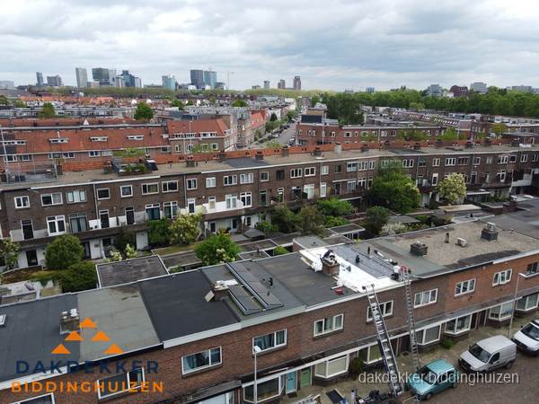 Spoed dakdekker aan het werk op plat dak in woonwijk Biddinghuizen