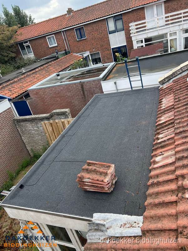 Aanbouw plat dak met reservepannen voor dakpannen vervangen in Biddinghuizen