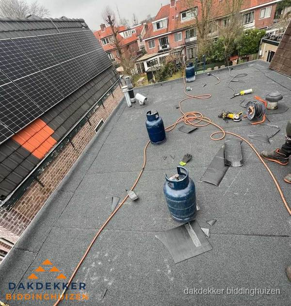 Daklekkage repareren met brandgereedschap op plat dak in Biddinghuizen