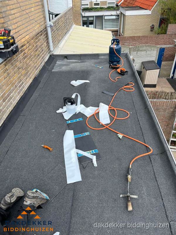 Dakdekkers bezig met bitumen dakbedekking in Biddinghuizen