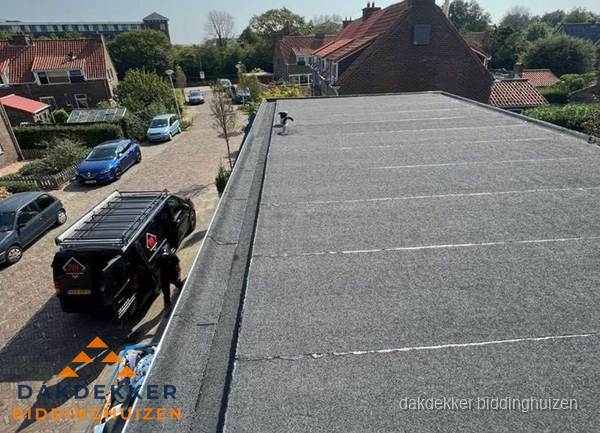 Nieuw bitumen plat dak met uitzicht over woonwijk in Biddinghuizen