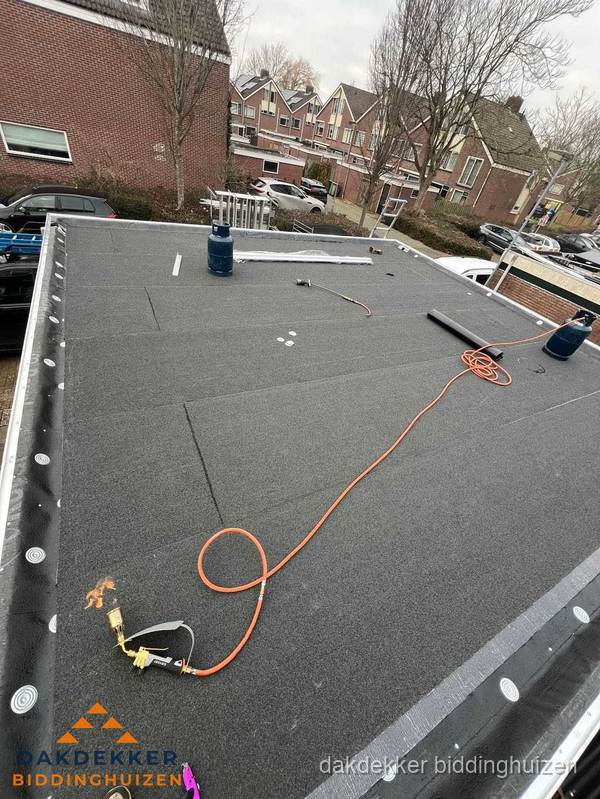 Afgewerkte dakrenovatie met bitumen op plat dak in Biddinghuizen