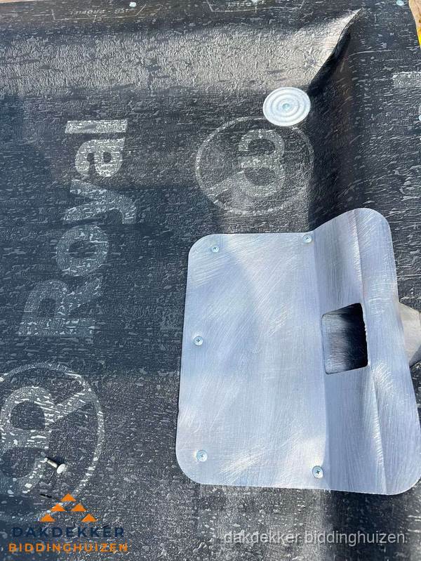 Dakdoorvoer met metalen afvoerplaat op bitumen dak in Biddinghuizen